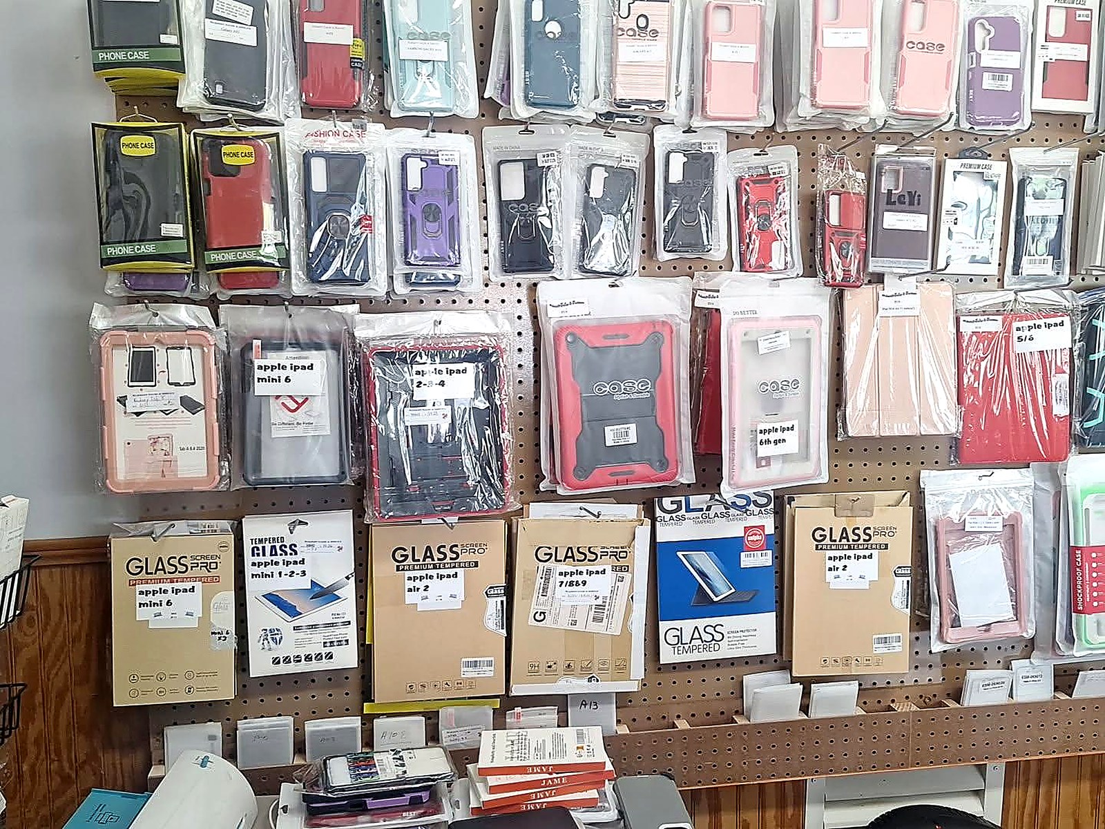 Pegboard wall stocked with iPad and tablet cases plus tempered glass screen protectors available in the Macon shop